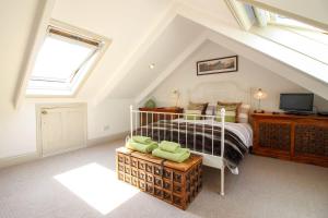 a bedroom with a bed and a television in a attic at The Customs House in St Austell