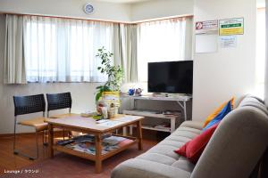 a living room with a couch and a table at Guest House Tokyo Azabu in Tokyo