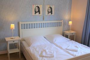 1 dormitorio con 1 cama blanca y 2 mesitas de noche en Pastis - Staffless with Self Check-In, en Pillig
