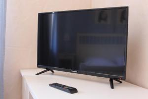 a television sitting on a table with a remote control at Pastis - Staffless with Self Check-In in Pillig