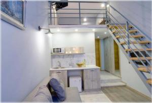 a room with a staircase and a kitchen with a couch at BestKievApartment in Kyiv