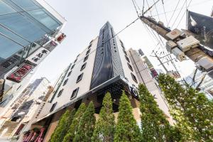 a tall building with trees in front of it at Forestar Hotel Sinchon in Seoul