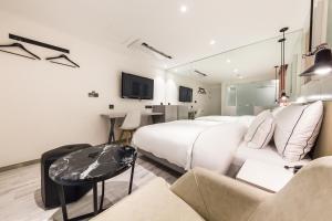 a hotel room with two beds and a table at Forestar Hotel Sinchon in Seoul