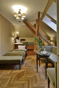 a room with four beds and a table and a chandelier at Gerlóczy Boutique Hotel in Budapest