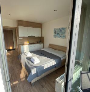 Apartment Poprad في بوبراد: غرفة نوم صغيرة بها سرير ومطبخ