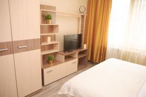 a bedroom with a bed and a tv on a shelf at Заречная 1-ая, 6 in Kemerovo