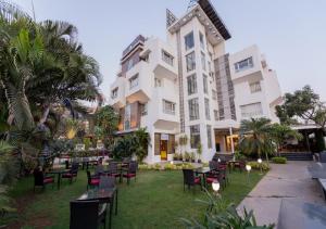 a hotel with tables and chairs in front of a building at Click Hotel Nashik in Nashik