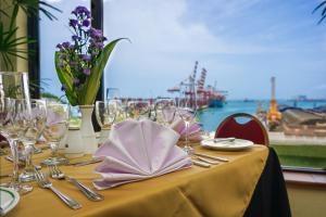 un tavolo con bicchieri e tovaglioli sopra con vista sull'oceano di Grand Oriental Hotel a Colombo