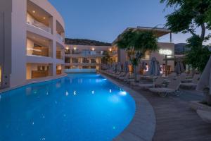 a large swimming pool in a hotel at night at Cactus Beach Hotel in Stalís