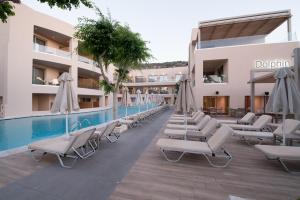 una fila di sedie a sdraio accanto alla piscina di Cactus Beach Hotel a Stalida