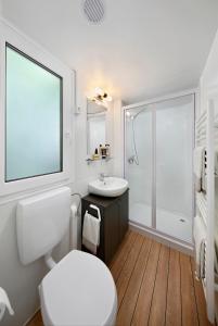 a white bathroom with a toilet and a sink at Knaus Campingpark Nürnberg in Nürnberg +14 photos