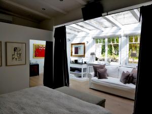 ein Schlafzimmer mit einem Bett und ein Wohnzimmer in der Unterkunft Am Eichholz Galerie & Art-Hotel in Murnau am Staffelsee