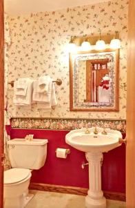Mariposa Hotel Inn في ماريبوسا: حمام مع مرحاض ومغسلة ومرآة