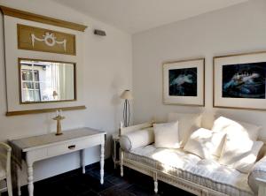 ein Wohnzimmer mit einem weißen Sofa und einem Kreuz an der Wand in der Unterkunft Am Eichholz Galerie & Art-Hotel in Murnau am Staffelsee