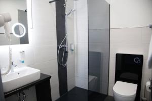 W łazience znajduje się prysznic, toaleta i umywalka. w obiekcie Hotel im Kaiserpark w mieście Meiningen
