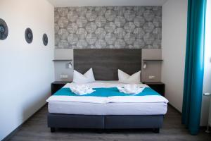 a bedroom with a bed with two white flowers on it at Hotel im Kaiserpark in Meiningen