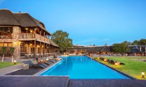 un complexe avec une piscine et un bâtiment dans l'établissement Aquila Private Game Reserve & Spa, à Touwsrivier