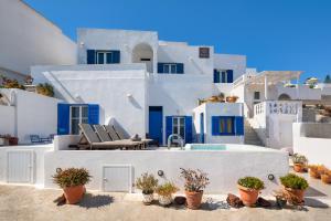a white and blue house with two white chairs at Afrodete Hotel in Firostefani