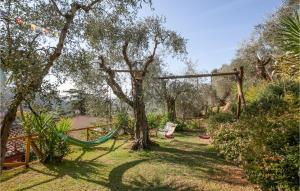 a hammock in a garden with trees and a swing at Beautiful Home In Sgiuliano Terme Pi in Asciano Pisano