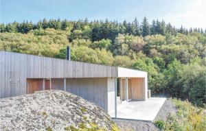 a house on top of a hill with a rock at Nice Home In Lyngdal With 3 Bedrooms And Wifi in Lyngdal