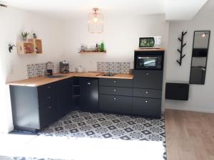 y cocina con encimera, microondas y nevera. en Appartement Pierres de Loire- Linge inclus -1er étage, en La Bohalle