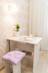 une table blanche avec un tabouret rembourré violet dans une pièce dans l'établissement Апартаменты Красная, 10Б, à Kemerovo