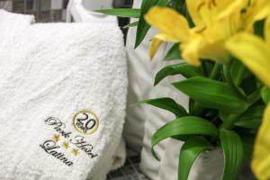 un paio di asciugamani bianchi seduti accanto a una pianta di Park Hotel a Latina