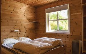 a bedroom with a bed in a wooden wall at 3 Bedroom Lovely Home In Vallavik in Vangsbygd