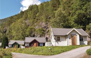 a group of houses on a road next to a mountain at 3 Bedroom Lovely Home In Vallavik in Vangsbygd