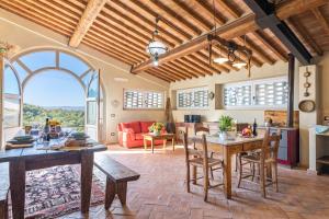 cocina y sala de estar con mesa y sillas en Podere Albereto en Buonconvento