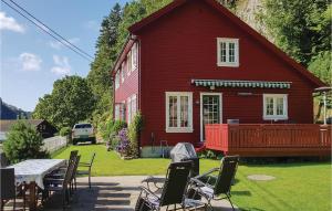 ein rotes Haus mit einem Tisch und Stühlen davor in der Unterkunft Lovely Home In Farsund With Wifi in Farsund