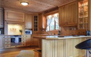 a kitchen with wooden cabinets and a large island at 4 Bedroom Cozy Home In Farsund in Farsund