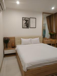 a bedroom with a large white bed in a room at Minh Apartment in Danang +53 photos