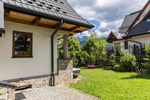 una casa con una pared de piedra y un techo en TatryTop Figaro, en Kościelisko