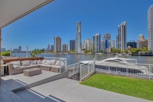 a house with a balcony with a boat in the water at 29 Stanhill drive in Gold Coast