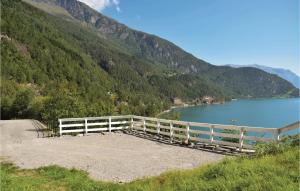 a white fence next to a lake with a mountain at 1 Bedroom Cozy Home In Vallavik in Kaland
