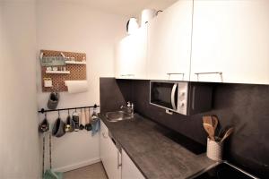 a kitchen with white cabinets and a microwave at Cozy and stylish Studioapartment in Würzburg