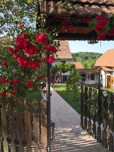 a fence with a bunch of red roses on it at Mánfa-gyöngy Vendégház in Mánfa