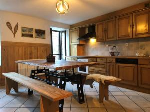 a kitchen with wooden cabinets and a wooden table and benches at Le Coustou 22 in Ax-les-Thermes