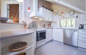 a kitchen with white cabinets and a sink at Awesome Home In Blåvand With Wifi in Blåvand