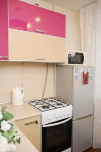 a kitchen with a stove and a refrigerator at Апартаменты Мичурина 21 in Kemerovo
