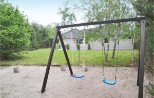 a swing set in a yard with a house at Pet Friendly Home In Ansager With Sauna in Ansager
