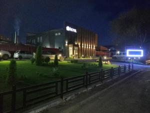 a building with a fence in front of it at night at Altyn Shatyr Hotel and Restaurant in Aksay