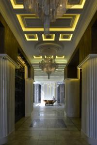 um corredor com um lustre num edifício em Shato Hotel em Omsk