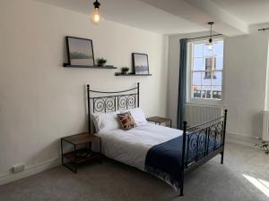 a bedroom with a black bed and a window at 1 Central Chambers in Stratford-upon-Avon