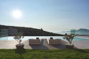 two couches sitting on a patio next to a pool at Villa Niolos II in Stérnai