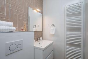 a white bathroom with a sink and a mirror at Villa Four Brothers - Exclusive Apartment in Podstrana +42 photos
