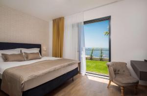 una camera con letto, finestra e sedia di Villa Four Brothers - Exclusive Apartment a Podstrana