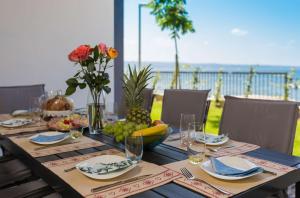 un tavolo con cibo e fiori sopra di Villa Four Brothers - Exclusive Apartment a Podstrana