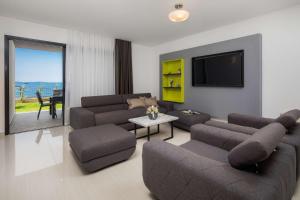un soggiorno con divani e TV a schermo piatto di Villa Four Brothers - Exclusive Apartment a Podstrana